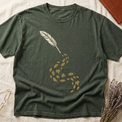 Green tee with antique quill pen in cream linework, oak and maple leaves cascading from the nib in gold and green.