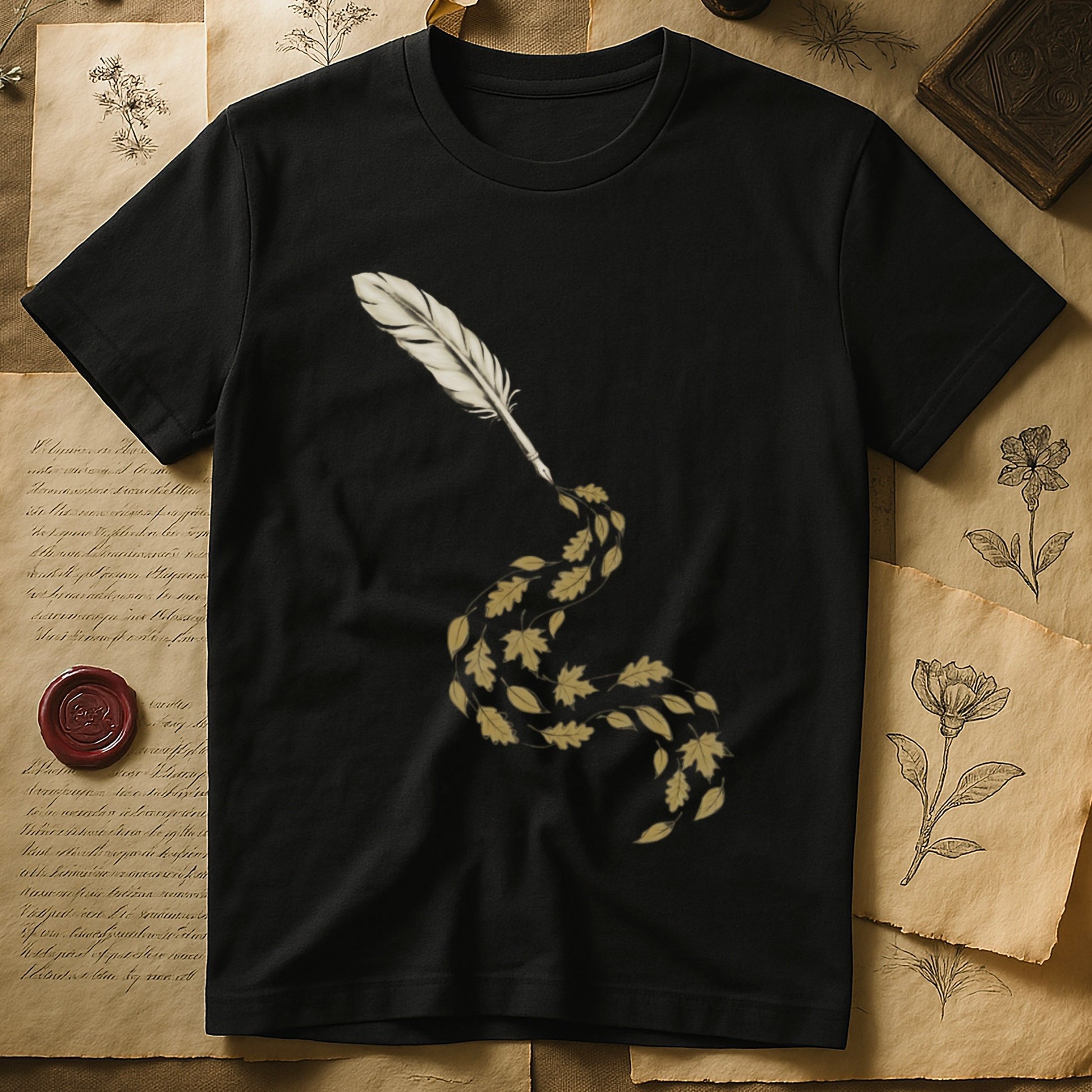 Black tee with antique quill pen in cream linework, oak and maple leaves cascading from the nib in gold and green.