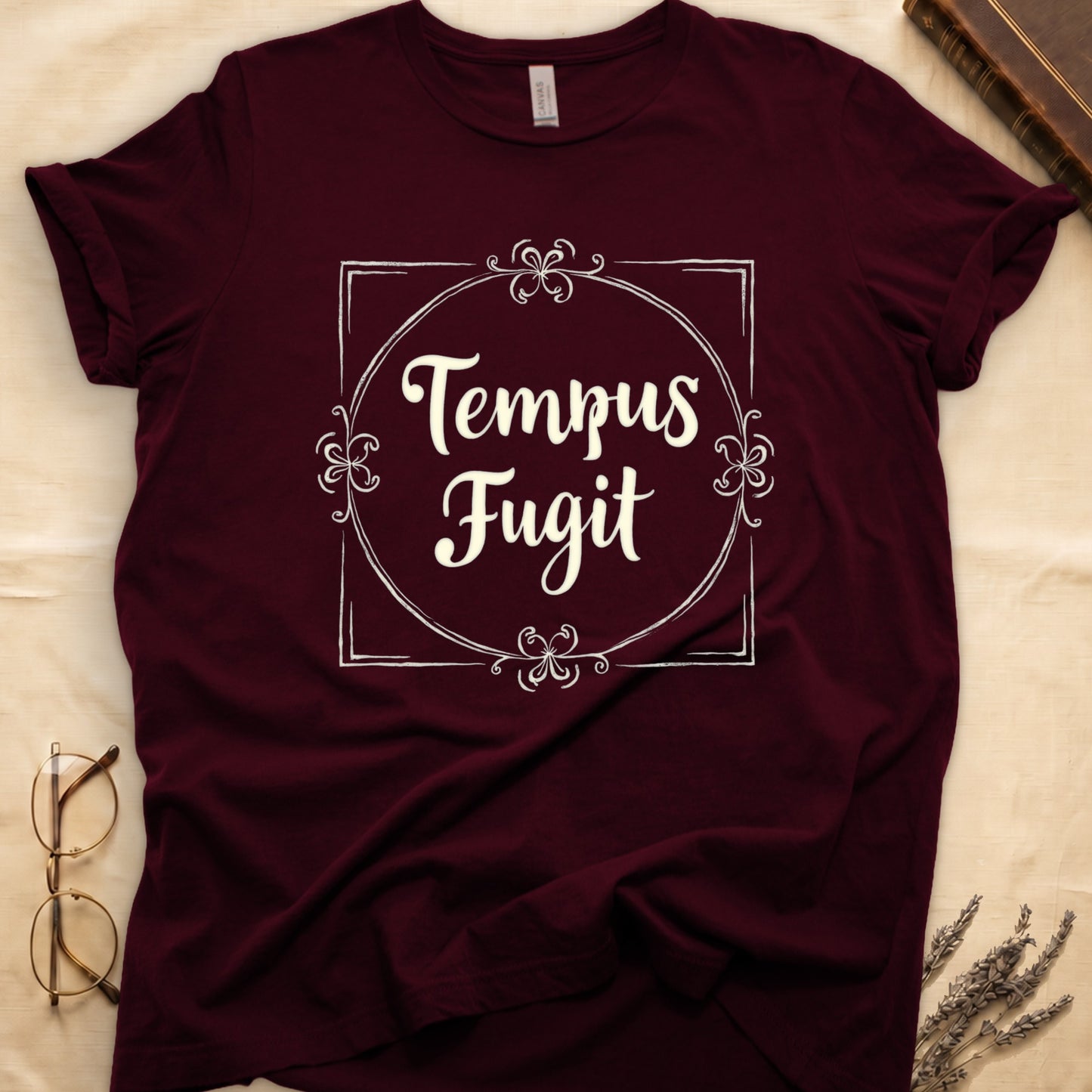 Maroon tee with cream "Tempus Fugit" script inside square filigree frame, decorative corner flourishes, classical typography.