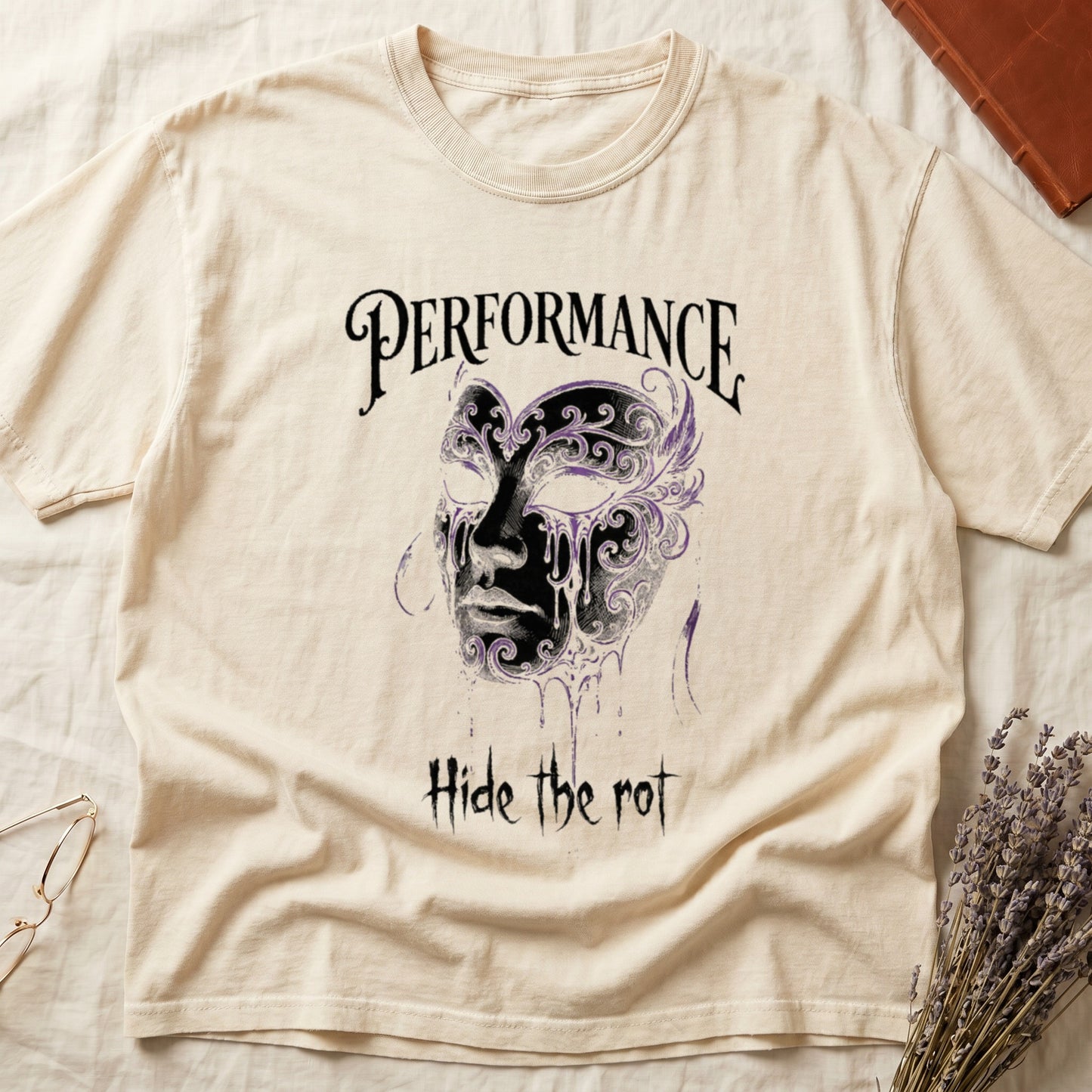 Ivory tee with ornate Venetian mask in cream and purple filigree dripping ink, "PERFORMANCE" top, "Hide the rot" below.