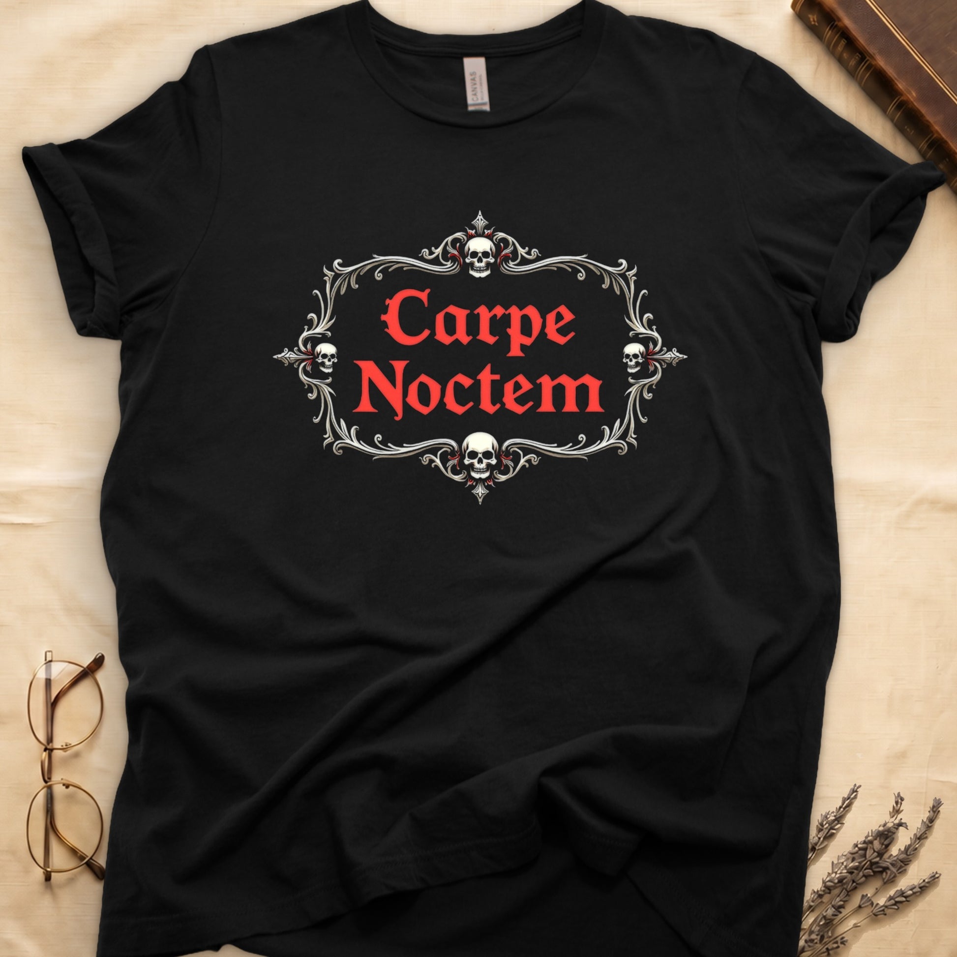 Black tee with silver filigree cartouche, crowned skull top and skull below, "Carpe Noctem" in deep-red blackletter inside.