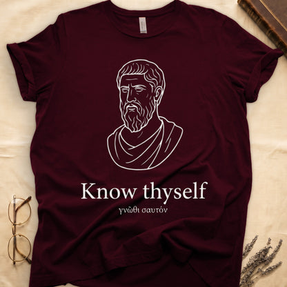 Maroon tee with classical Greek philosopher bust in white linework, "Know thyself" in cream serif below.