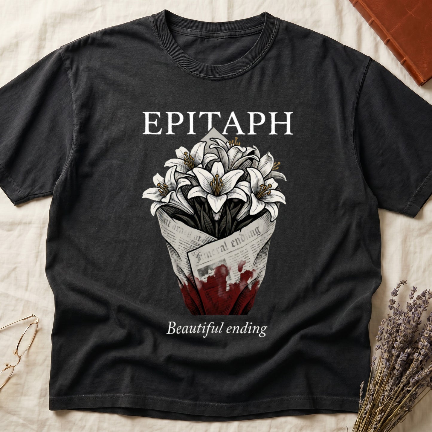 Black tee with "EPITAPH" over crosshatched white lilies in blood-stained newsprint wrap, "Beautiful ending" italic serif.