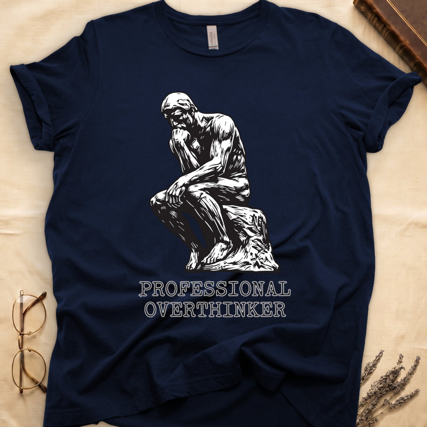 Navy tee with monochrome rendering of Rodin's Thinker, "PROFESSIONAL OVERTHINKER" in serif capitals below.