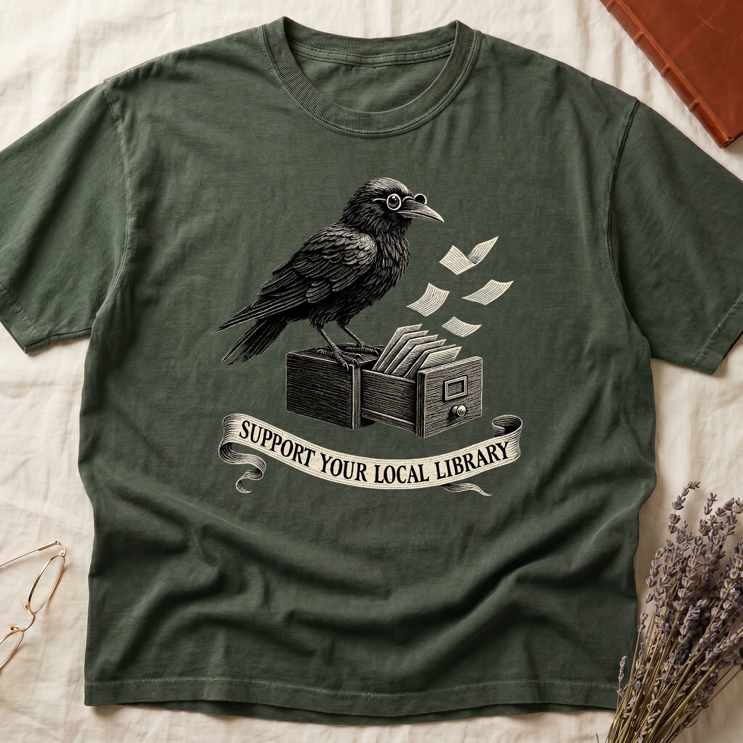 Dark Rose tee with raven writing on "823.4" parchment by candlelight, ink jar beside, "MIDNIGHT CATALOGUER" banner above.