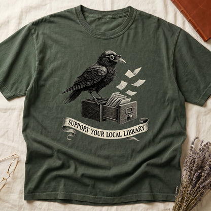 Dark Rose tee with raven writing on "823.4" parchment by candlelight, ink jar beside, "MIDNIGHT CATALOGUER" banner above.