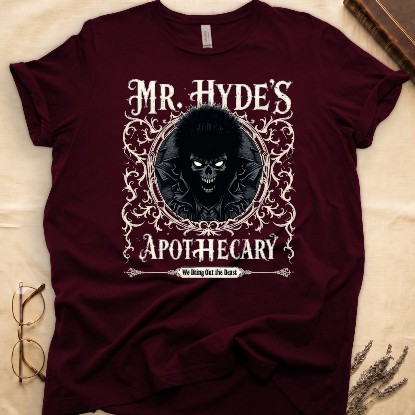 Navy tee with ornate filigree frame, wild-haired skull figure, "MR. HYDE'S APOTECARY," "We Bring Out the Beast" below.