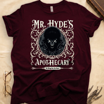 Navy tee with ornate filigree frame, wild-haired skull figure, "MR. HYDE'S APOTECARY," "We Bring Out the Beast" below.