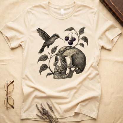 Natural tee with sepia engraved skull, nightshade vine and dark-purple berries wrapping around, hummingbird at upper left.