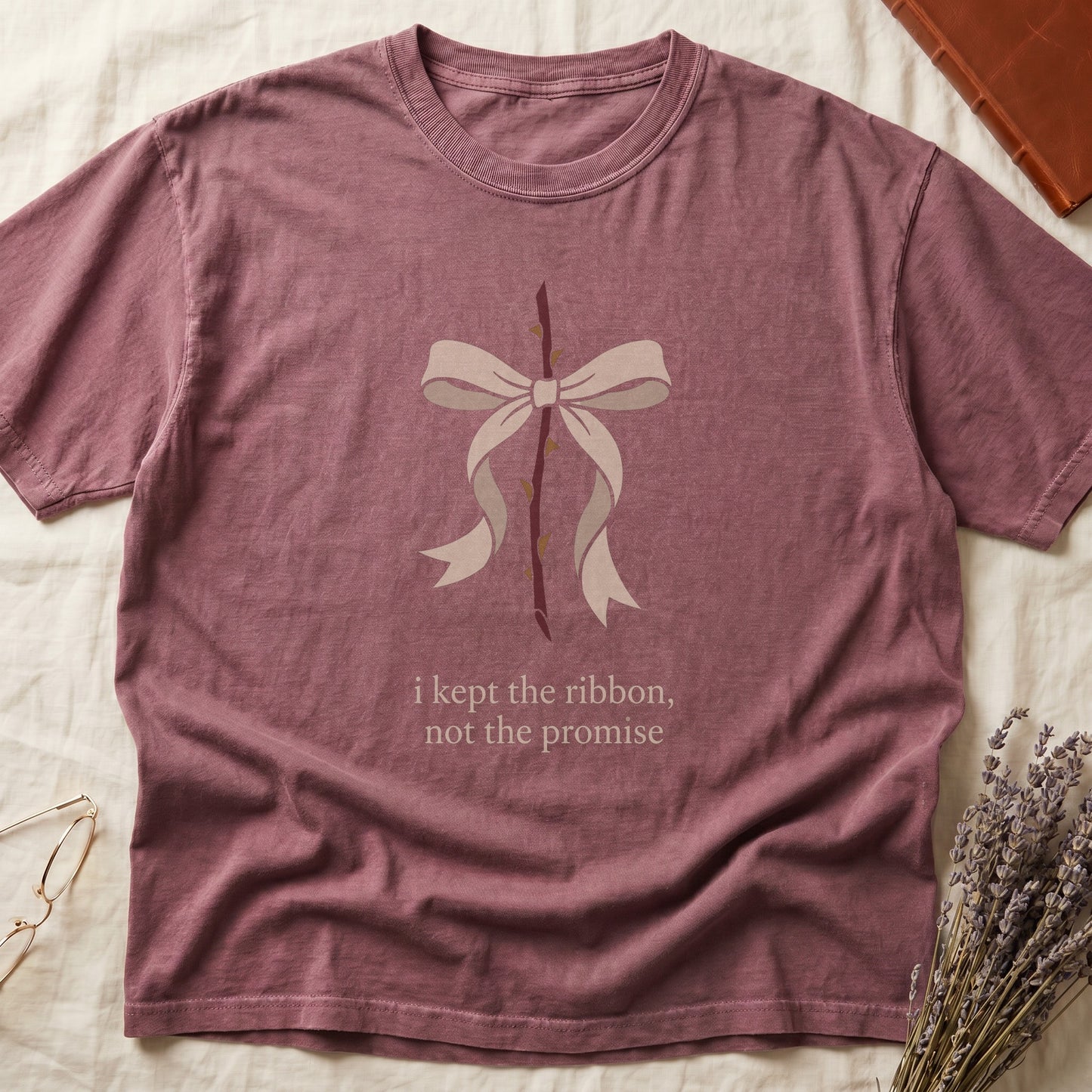 Dark Rose tee with cream bow tied around thorny rose stem, "i kept the ribbon, not the promise" in cream serif below.