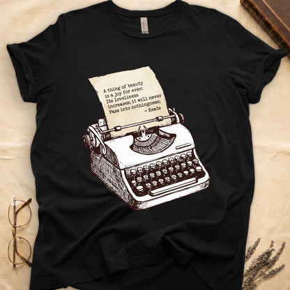 Black tee with vintage typewriter in cream linework, paper showing "A thing of beauty is a joy for ever" by Keats.