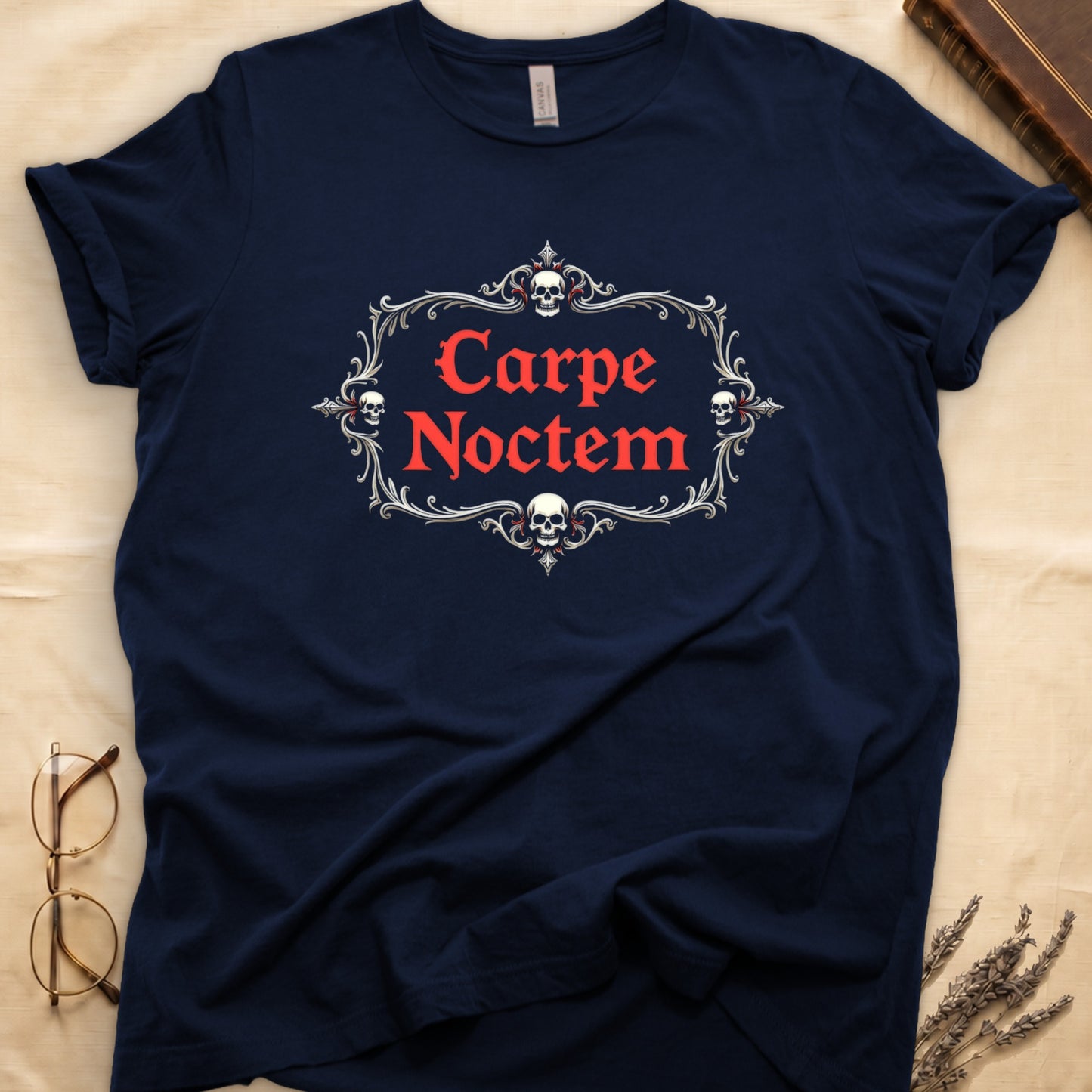 Navy tee with silver filigree cartouche, crowned skull top and skull below, "Carpe Noctem" in deep-red blackletter inside.