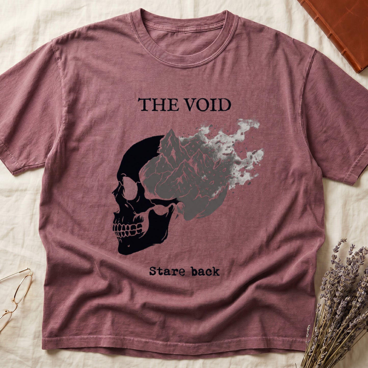 Dark Rose tee with skull eroding into mountain landscape and stardust, "THE VOID" top, "Stare back" typewriter below.