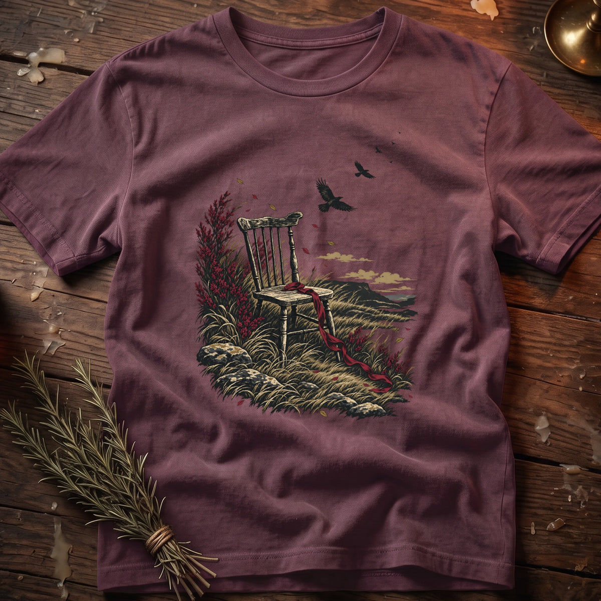 T-shirt with a dark plum color featuring an illustration of a chair with a red ribbon and birds.