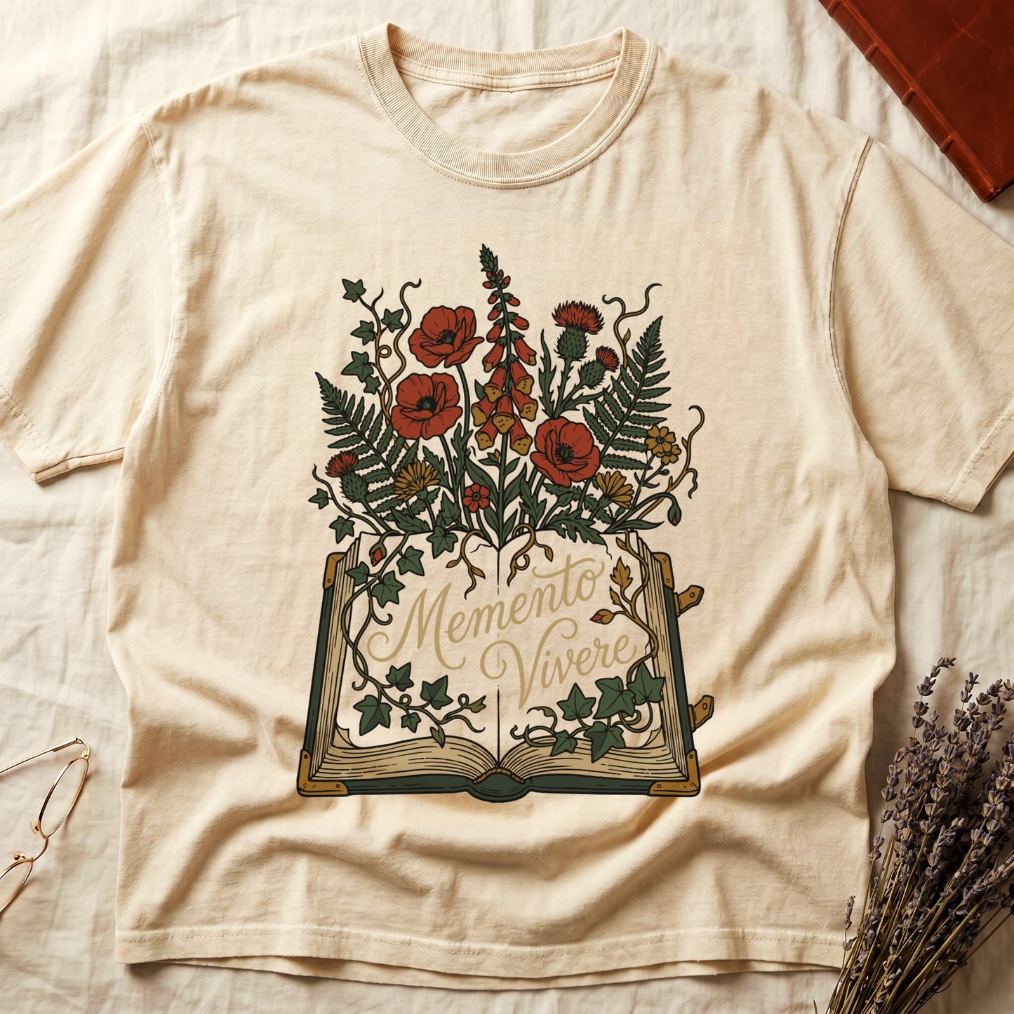Ivory tee with open book and botanical illustration, red poppies, golden foxglove, ferns and ivy spilling from the pages.