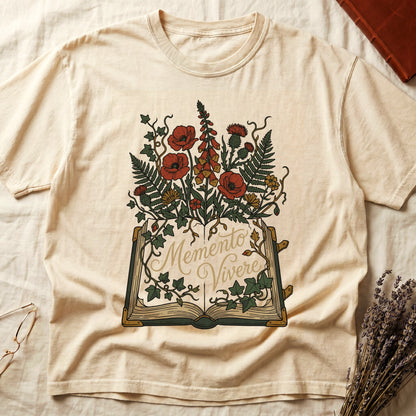 Ivory tee with open book and botanical illustration, red poppies, golden foxglove, ferns and ivy spilling from the pages.