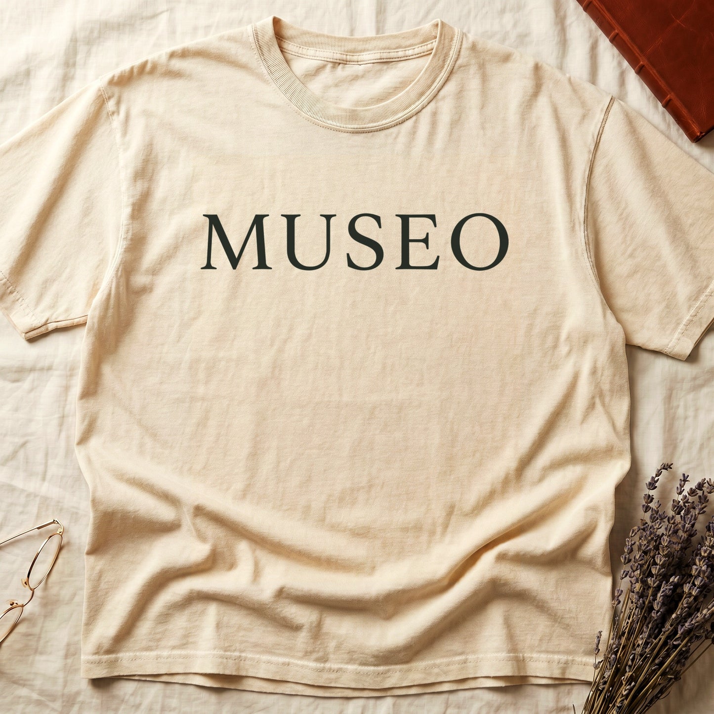 Ivory tee with "MUSEO" in oversized cream serif capitals, minimalist typographic design.