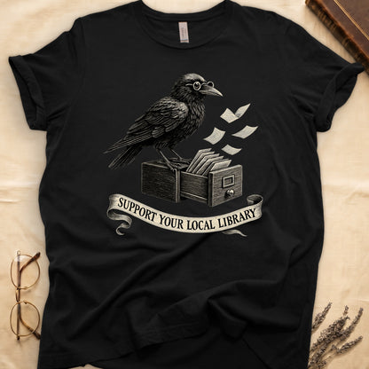 Military Green tee with raven writing on "823.4" parchment by candlelight, ink jar beside, "MIDNIGHT CATALOGUER" banner above.