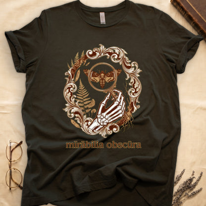 Military Green tee with skeletal hand, magnifying glass, death's-head moth, ferns on green, "mīrābilia obscūra" in Latin italic.