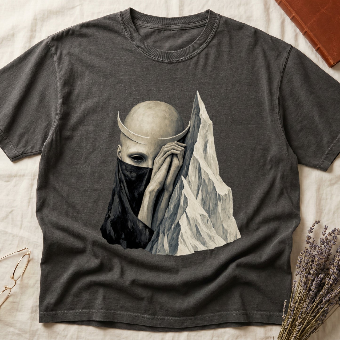Dark grey t-shirt with a minimalist surrealist illustration of a figure and mountain.