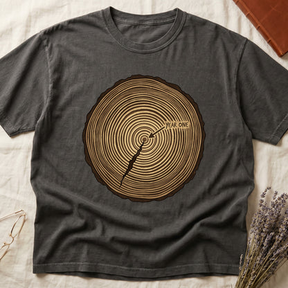 Pepper tee with cross-section of tree rings in warm brown, arrow pointing to center labeled "YEAR ONE" in serif type.