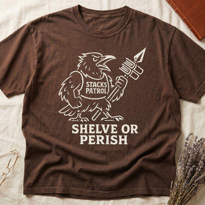 Espresso tee with vintage raven mascot, "STACKS PATROL" sash, feather pen aloft, "SHELVE OR PERISH" bold serif below.