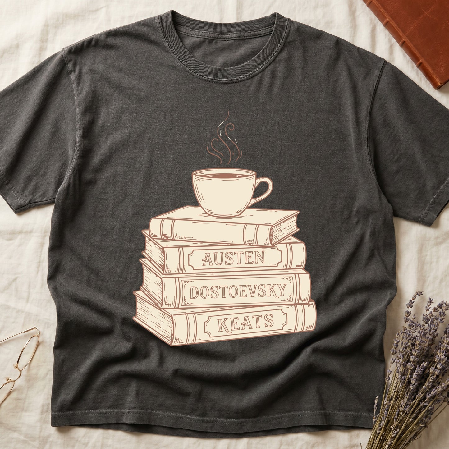 Pepper tee with stack of vintage books labeled "AUSTEN," "DOSTOEVSKY," "KEATS" topped with a steaming coffee cup.