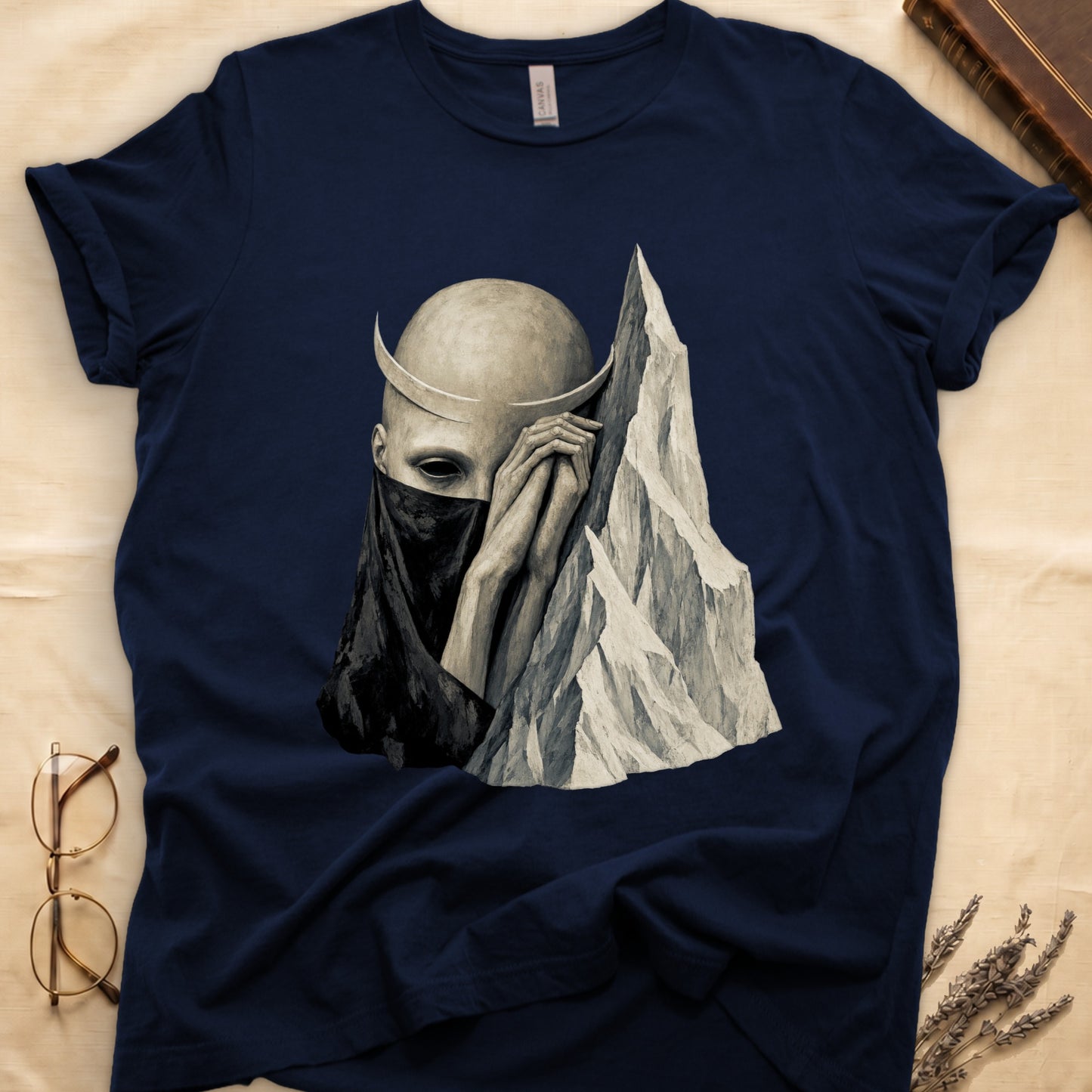 Dark t-shirt with surreal art of a horned figure and mountain peak.