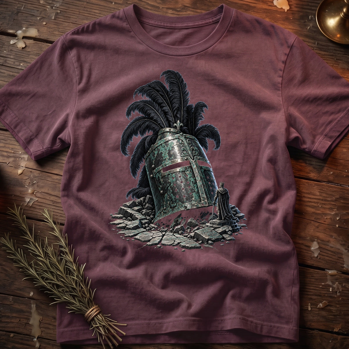 T-shirt graphic of a fallen knight's helmet with black plumes and a small king figurine.