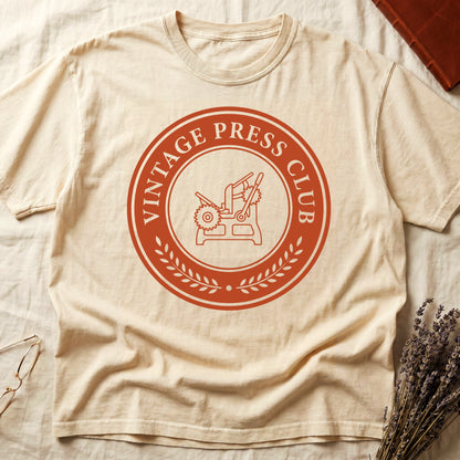 Ivory tee with circular letterpress badge, "VINTAGE PRESS CLUB" in serif capitals, antique printing press in cream linework.