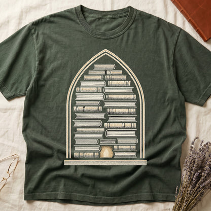 Green tee with gothic arch frame, columns of leather-bound books inside, sunburst medallion at base, cream engraved linework.