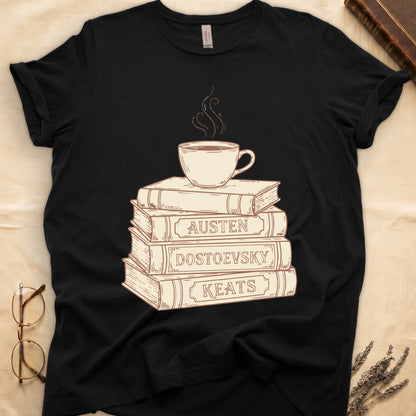 Black tee with stack of vintage books labeled "AUSTEN," "DOSTOEVSKY," "KEATS" topped with a steaming coffee cup.