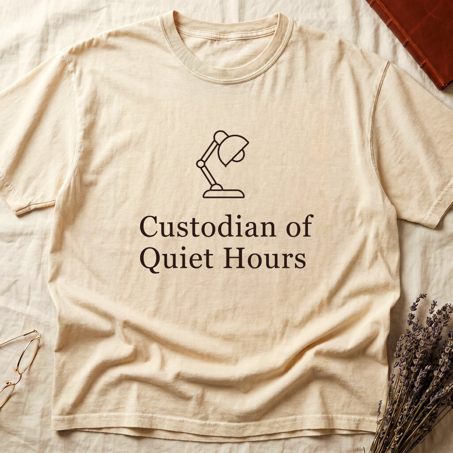 Ivory tee with vintage desk lamp in cream linework above "Custodian of Quiet Hours" in distressed Art Deco caps.