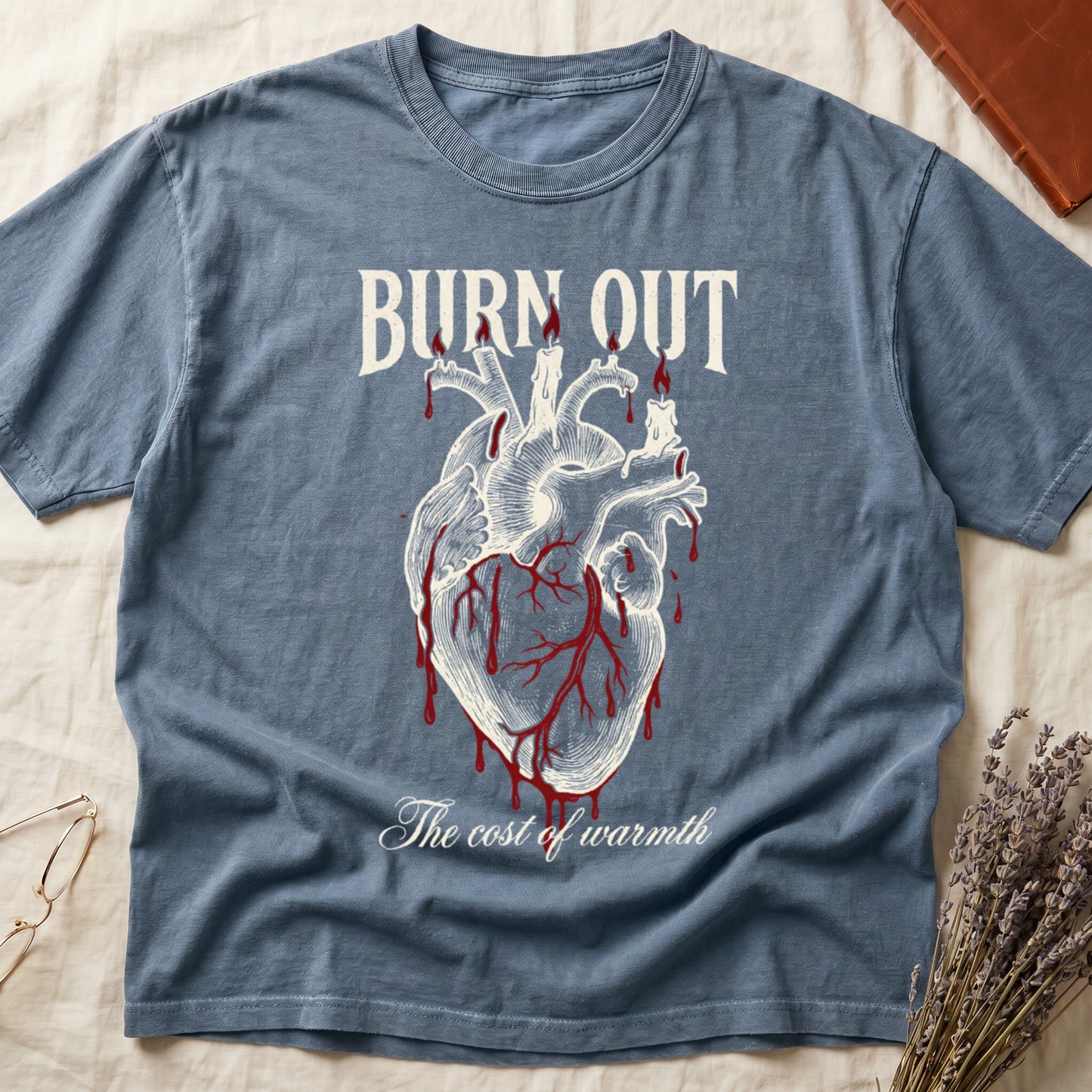 Blue Jean tee with anatomical heart and melted candles dripping red wax, "BURN OUT" top, "The cost of warmth" cursive below.