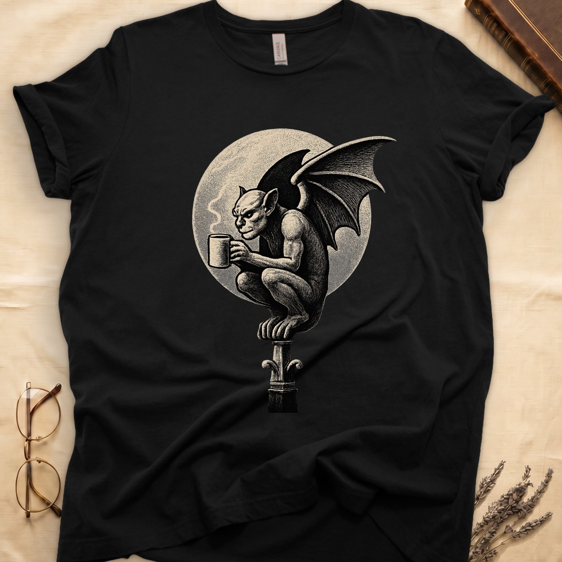 Black tee with gargoyle on stone pinnacle holding coffee mug, cream-parchment full moon behind, engraving style.