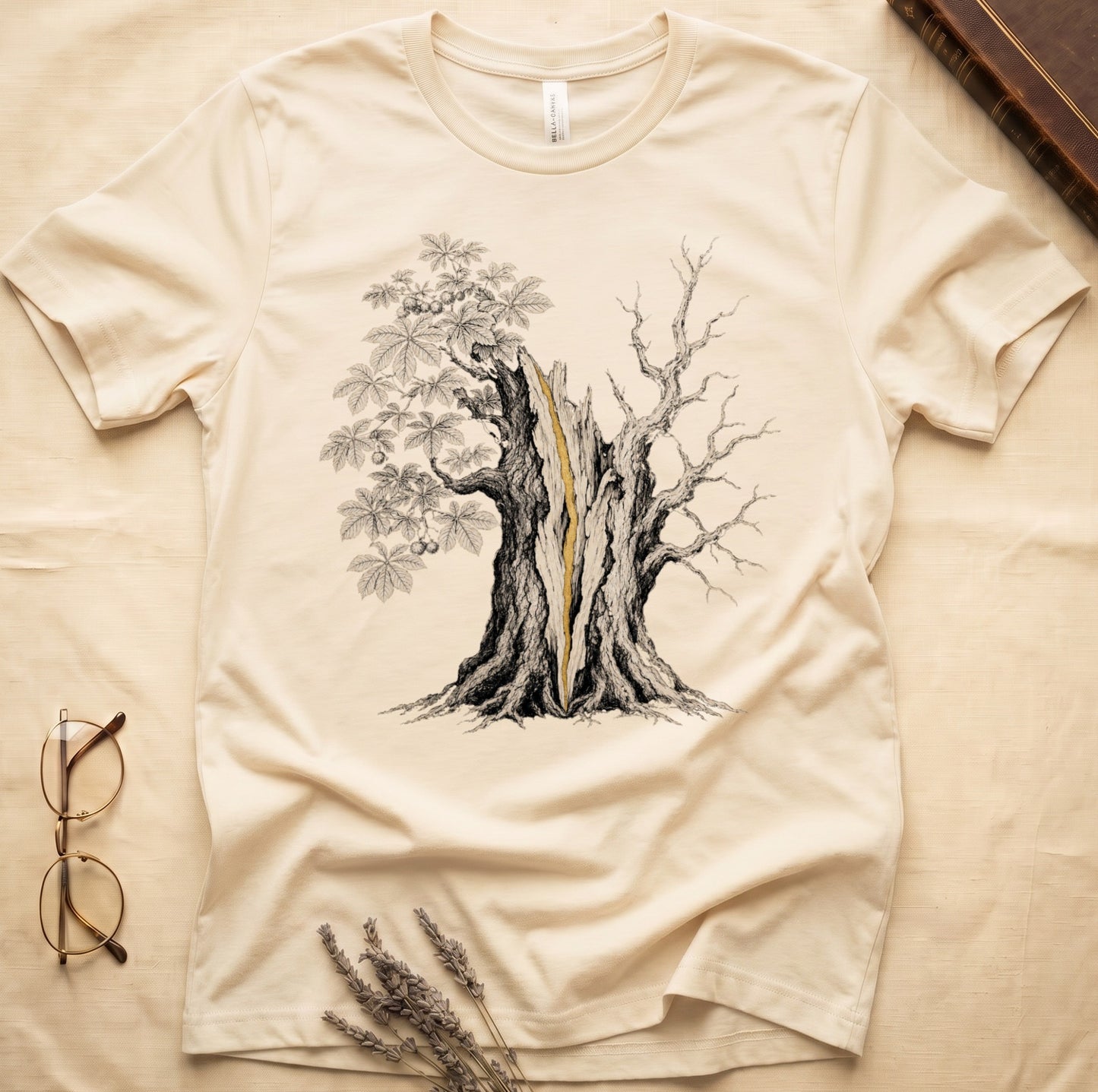 Cream t-shirt with a detailed black and white drawing of a split tree with golden center.