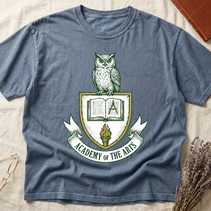 Blue Jean tee with heraldic shield crest, owl perched on top, open book and dividers center, "ACADEMY OF THE ARTS" on a banner.