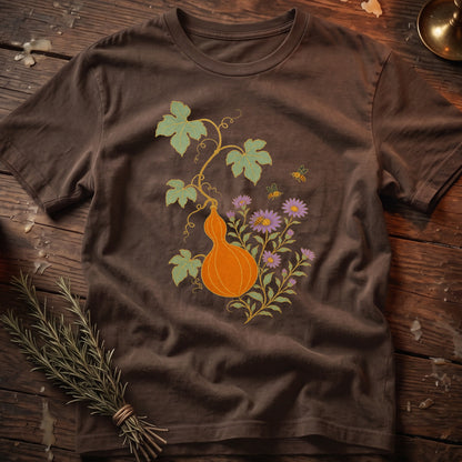 Brown t-shirt with a detailed print of an orange gourd, purple flowers, green leaves, and bees.