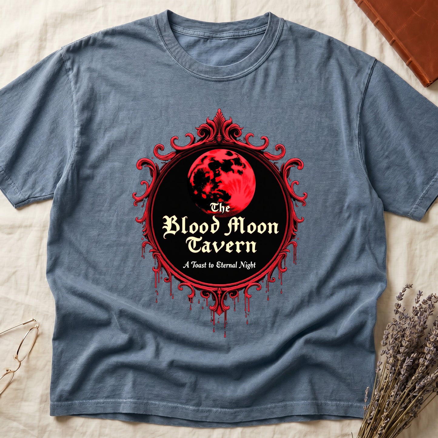 Blue Jean tee with red oval frame, blood-red moon, "The Blood Moon Tavern," "A Toast to Eternal Night," red drips below.