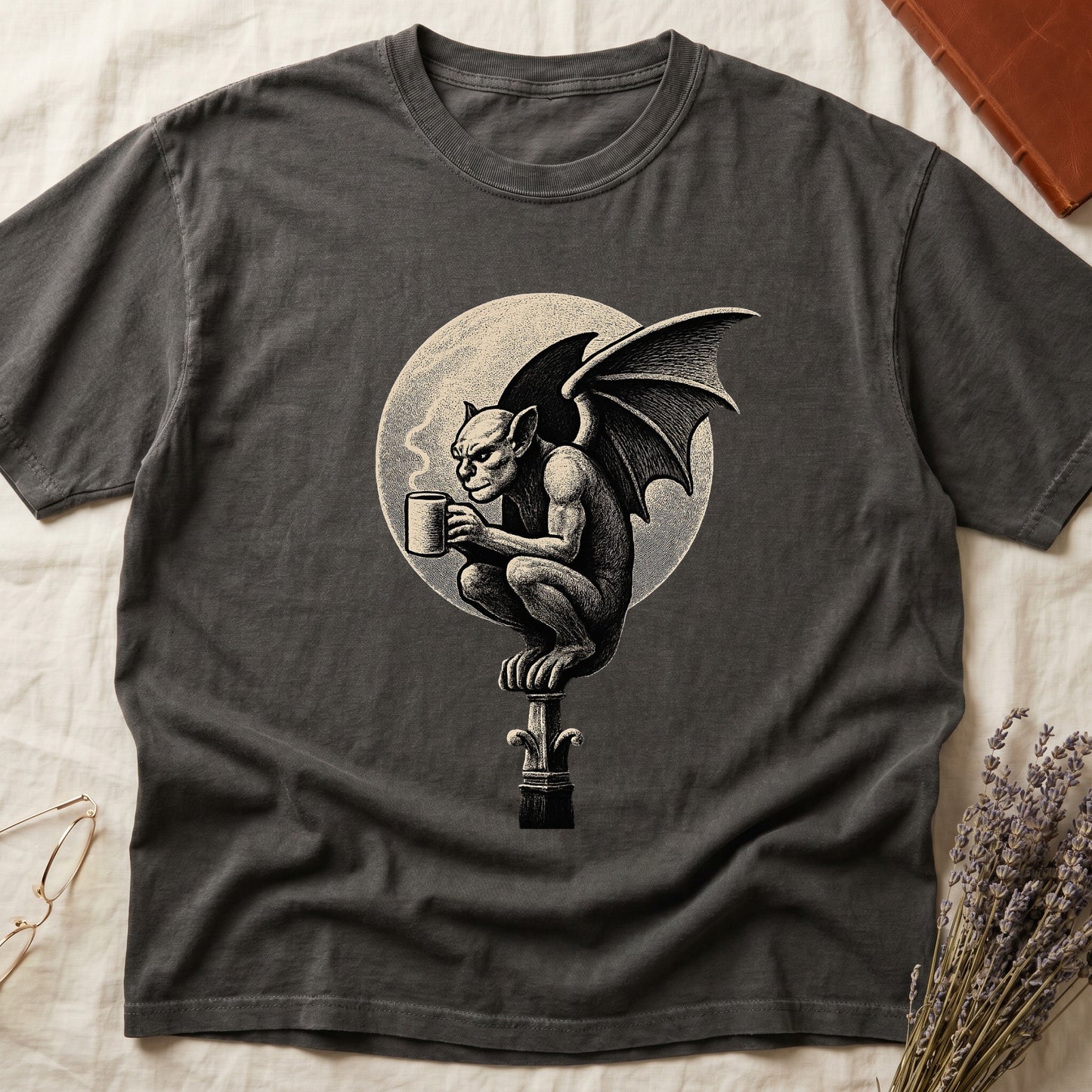Pepper tee with gargoyle on stone pinnacle holding coffee mug, cream-parchment full moon behind, engraving style.