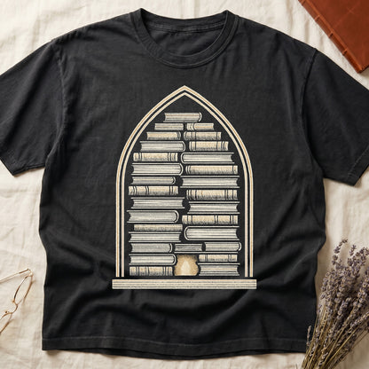 Black tee with gothic arch frame, columns of leather-bound books inside, sunburst medallion at base, cream engraved linework.