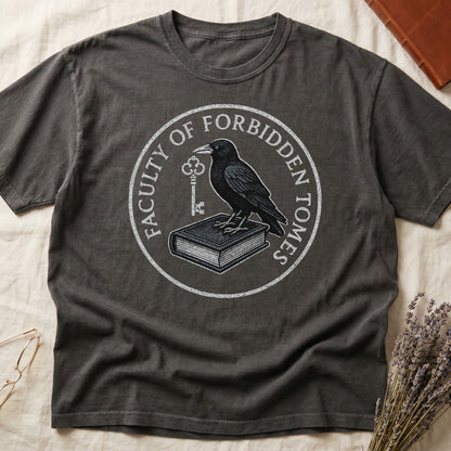 Green tee with circular badge, raven on closed book holding key, "FACULTY OF FORBIDDEN TOMES" curved around in cream.