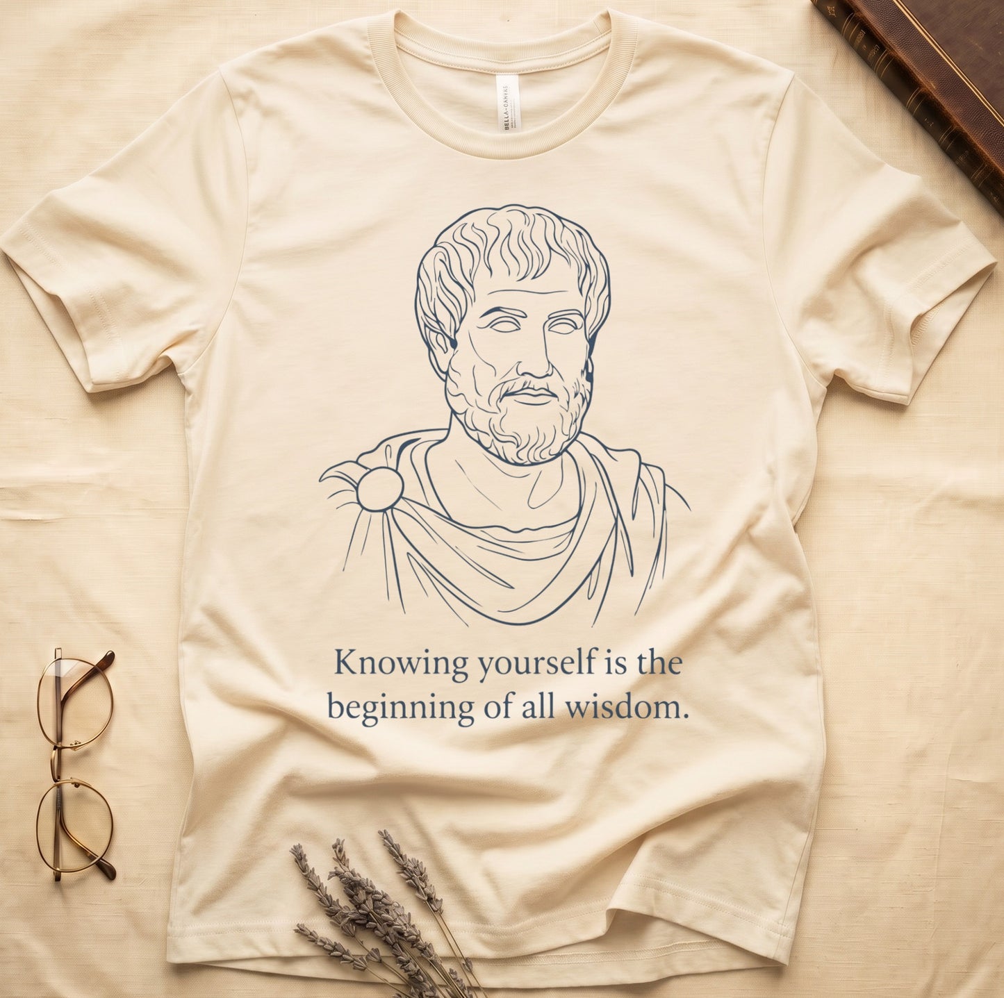 Natural tee with classical philosopher bust in cream linework, "Knowing yourself is the beginning of all wisdom" below.