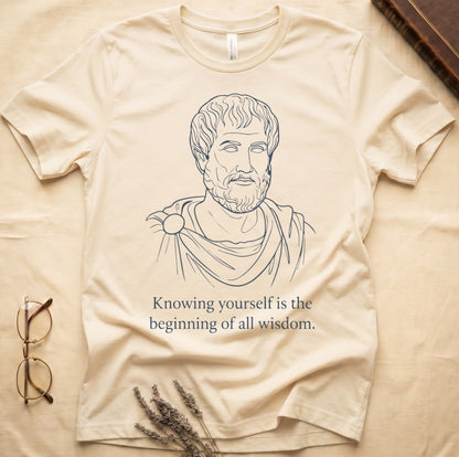 Natural tee with classical philosopher bust in cream linework, "Knowing yourself is the beginning of all wisdom" below.