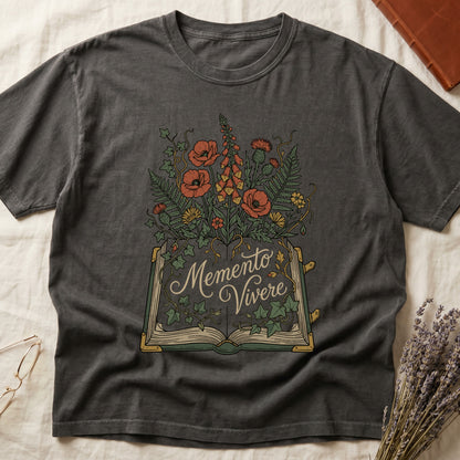 Pepper tee with open book and botanical illustration, red poppies, golden foxglove, ferns and ivy spilling from the pages.