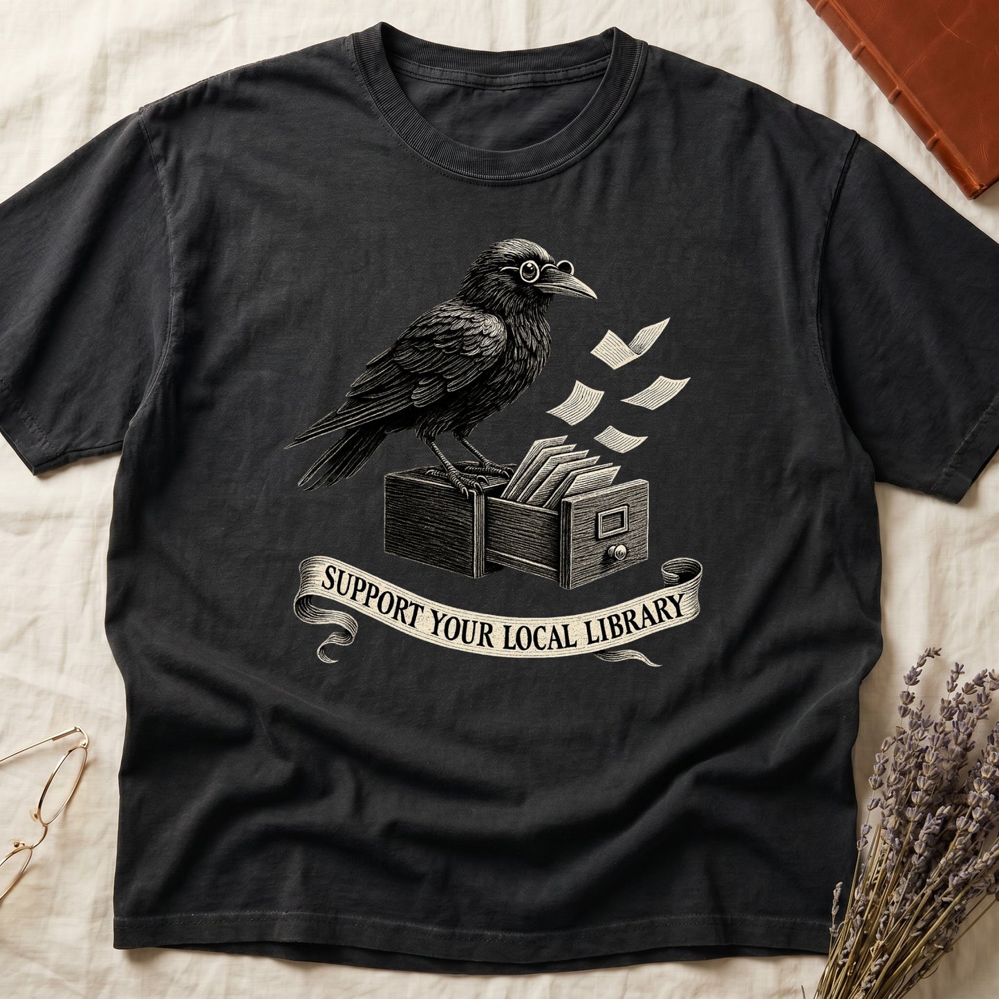Pepper tee with raven writing on "823.4" parchment by candlelight, ink jar beside, "MIDNIGHT CATALOGUER" banner above.