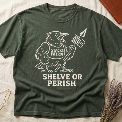 Green tee with vintage raven mascot, "STACKS PATROL" sash, feather pen aloft, "SHELVE OR PERISH" bold serif below.