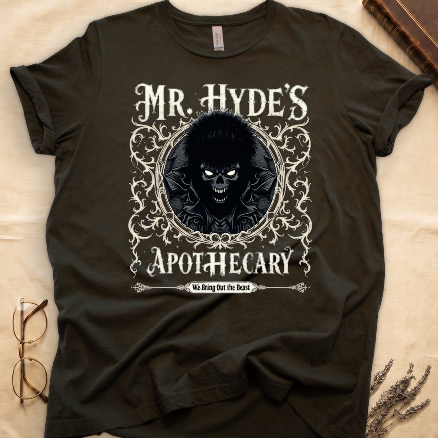 Maroon tee with ornate filigree frame, wild-haired skull figure, "MR. HYDE'S APOTECARY," "We Bring Out the Beast" below.