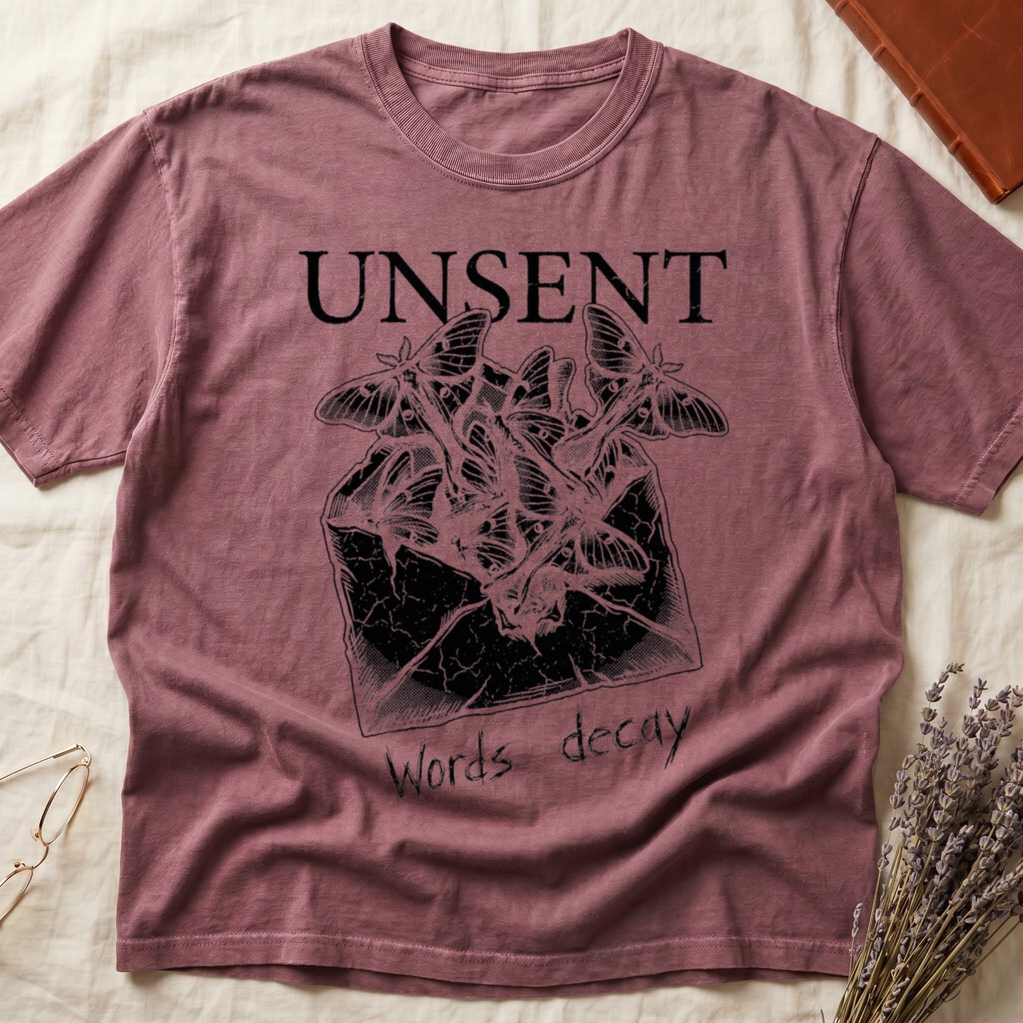 Dark Rose tee with 'UNSENT' in serif type, 'Words decay' brush text, luna moths from torn envelope in crosshatched ink
