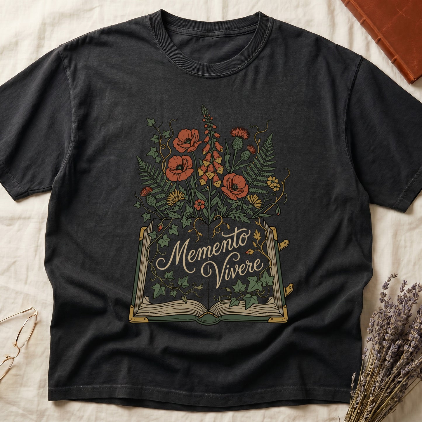Black tee with open book and botanical illustration, red poppies, golden foxglove, ferns and ivy spilling from the pages.